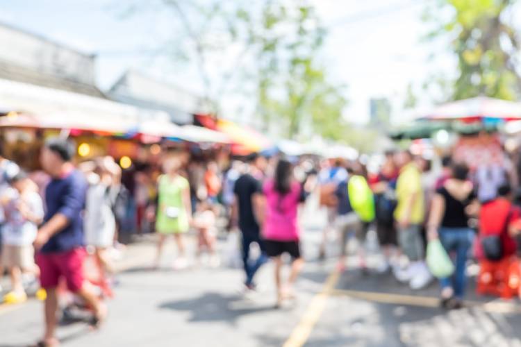 blurry image of people walking at an outdoor market